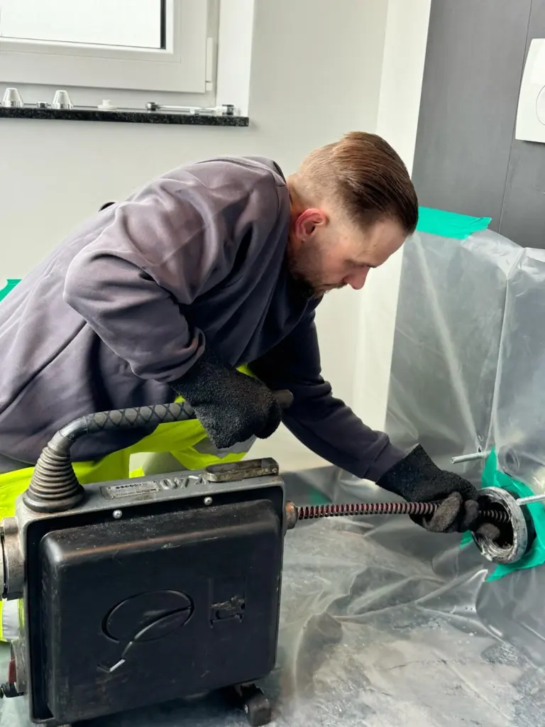 Fachmann von Firma Kraft führt eine Rohrreinigung in Altenkirchen mit Spirale an einer Toilette in durch